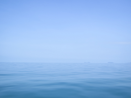 calm flat surface of ocean meeting cloudless clear blue sky at horison, in the gulf of thailand between koh samui and ko phanganの写真素材