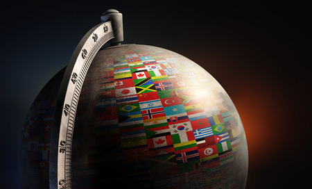 vintage metal desktop globe with nation flags on dark abstract backgroundの写真素材