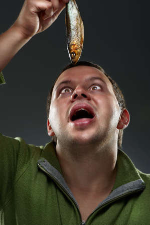 Hungry corpulent man staring at a fishの写真素材