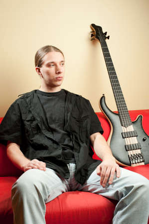 Portrait of young handsome musician with bass guitar