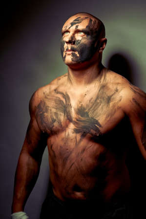 Emotional portrait of fighter. War paint on his face and bodyの写真素材