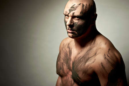 Emotional portrait of fighter. War paint on his face and bodyの写真素材