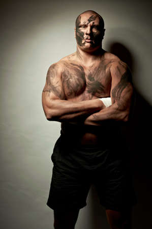 Emotional portrait of fighter. War paint on his face and bodyの写真素材