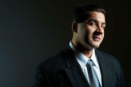 Dark portrait of handsome stylish young man in black suit, studio shotの写真素材