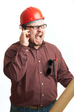 Serious builder in glasses and red hard hat with engineering drawing isolated on whiteの写真素材