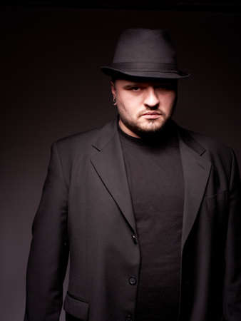 Handsome man in black suite with hatの写真素材