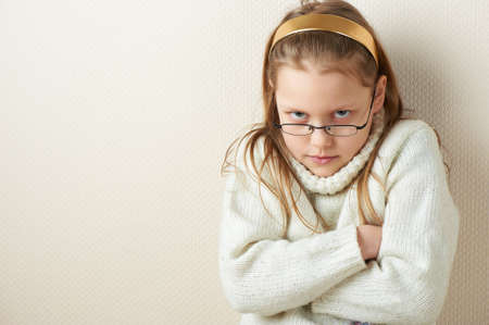 Portrait of a displeased little girl in eyeglasses, studio shotの写真素材