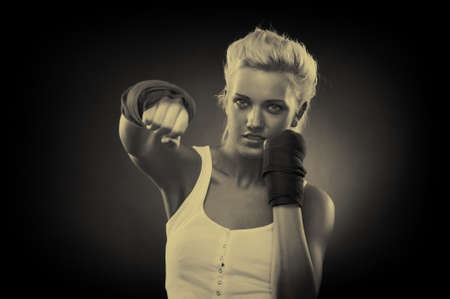 Attractive blonde fighter girl, studio shot, sepiaの写真素材