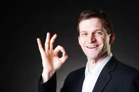 Studio dark portrait of a handsome stylish young man, positive studio portraitの写真素材