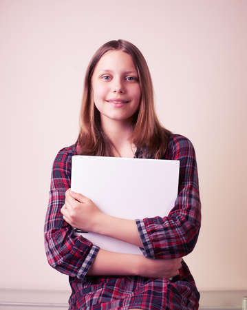 Portrait of a school girl with folder, studio shotの写真素材