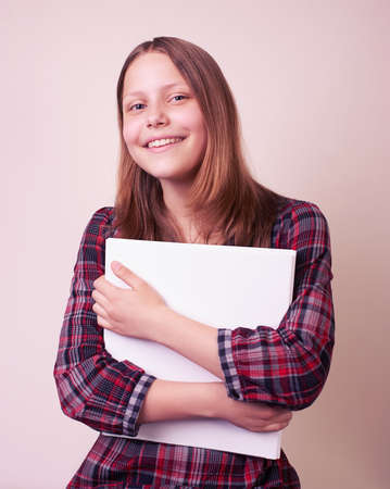Portrait of a school girl with folder, studio shotの写真素材