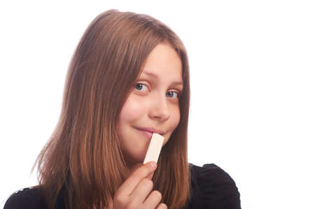 teen girl eating bubblegum on white background,studioshotの写真素材