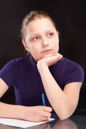 Teen girl thinking and writing somethingの写真素材