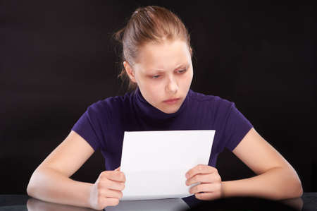 Misunderstanding teen girl reading letterの写真素材
