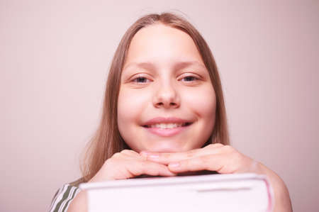Happy teen girl sitting with book and smilingの写真素材