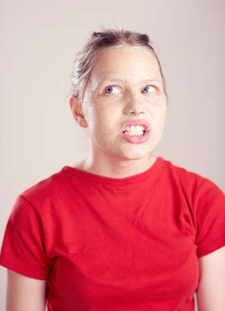 Happy teen girl with scrub mack on her face having fun and making funny faces