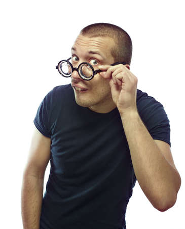 Young nerd with glasses looking at the camera and try to flirting, isolated on whiteの写真素材