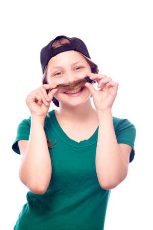 Beatiful teen girl in cap playing with her hair and smilingの写真素材