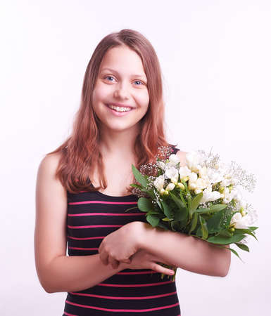 Cute happy teen girl with a bouquet of flowersの写真素材
