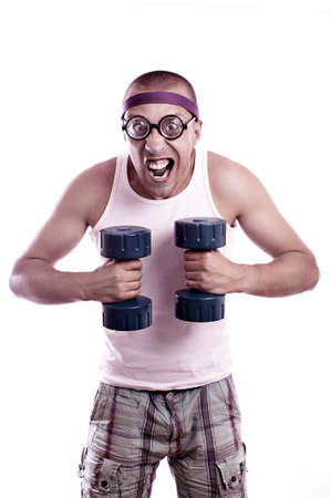 Portrait of a silly nerd in glasses with dumbbell trainsの写真素材