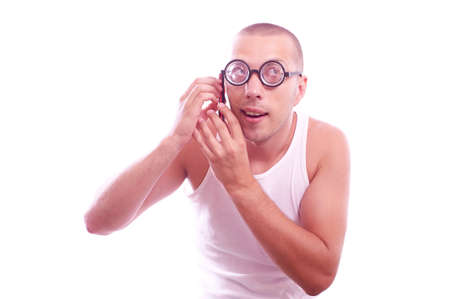 Portrait of a satisfied weird nerd in eyeglasses calls by mobile phone