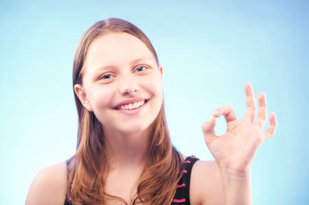 Nice cute smiling teen girl shows okの写真素材