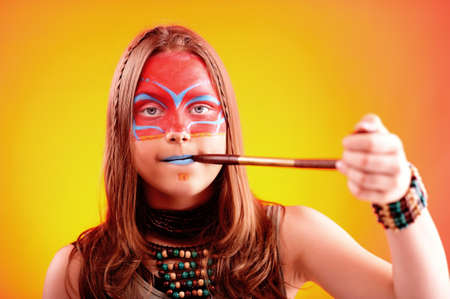 Portrait of a beautiful teen girl with make-up with smoking pipe
