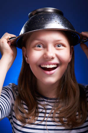Funny girl with a colander on her head is protected from the aliensの写真素材