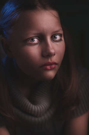 Portrait of a depressed teen girl sits and criesの写真素材