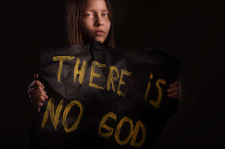 Atheist teen girl holding a banner with the inscription-"THERE IS NO GOD"の写真素材