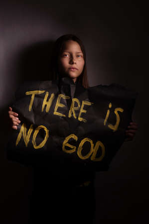 Atheist teen girl holding a banner with the inscription-"THERE IS NO GOD"の写真素材