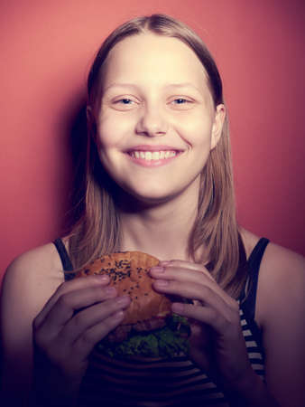Teen girl with a delicious burgerの写真素材