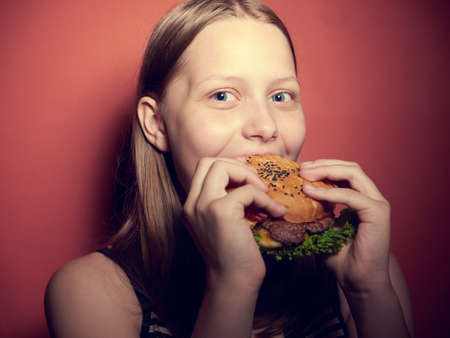 Teen girl with a delicious burgerの写真素材