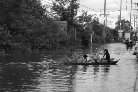 PATHUMTHANI, THAILAND - OCTOBER 16 : Unidentified people have to travel by boat on the road during flooding crisis, Pathumthani, Thailand on October 16, 2011.のeditorial素材