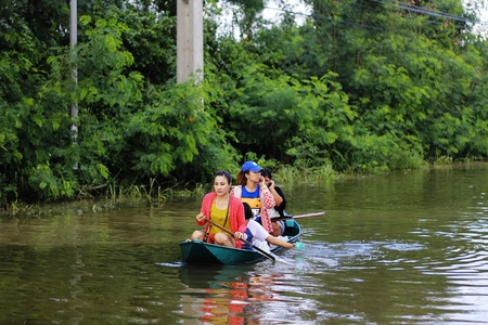 PATHUMTHANI, THAILAND - OCTOBER 16 : Unidentified people have to travel by boat on the road during flooding crisis, Pathumthani, Thailand on October 16, 2011.のeditorial素材