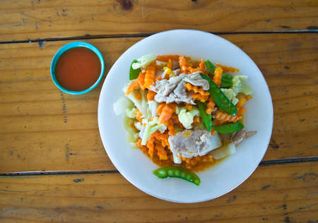 stir fried assorted vegetable and pork on wood tableの写真素材