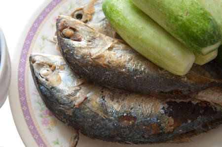 fried mackerel fishes with cucumber on dishの写真素材