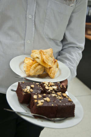 A hand holding a plate of sweets ready to serveの写真素材