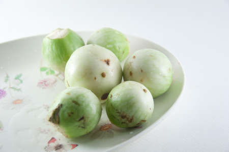 Fresh green eggplants in plate isolated on a white backgroundの写真素材