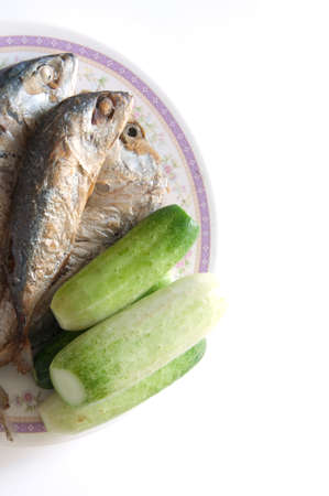 fried mackerel fishes with cucumber on dishの写真素材