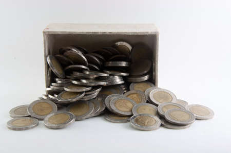 Thai coins in box and on ground on white backgroundの写真素材