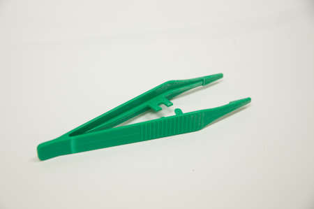 green plastic forceps isolated on white backgroundの写真素材