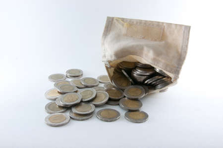 A small tattered cloth bag filled with 10 baht of thaiの写真素材