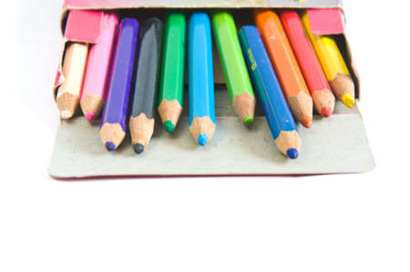 a stack of colored pencils in box on white backgroundの写真素材