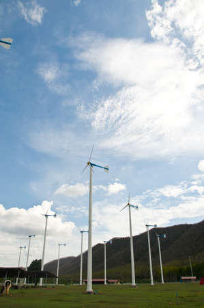 A wind wheel in front of a blue, overcast skyの写真素材