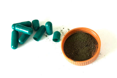 Herbal medicine capsules  opened with herbal powder falling out 