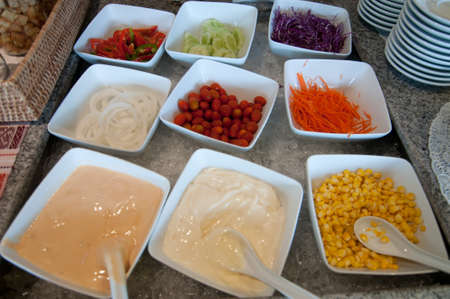 dressing and fresh vegetables on a salad barの写真素材