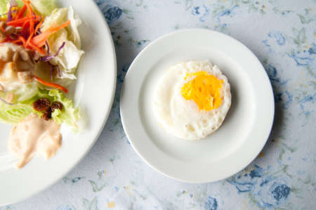 Fried eggs on white plateの写真素材
