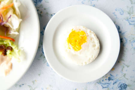 Fried eggs on white plateの写真素材