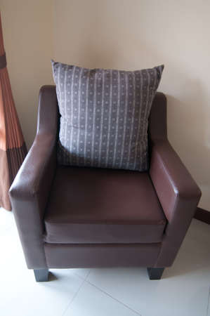 Pillows on a leather armchair in homeの写真素材
